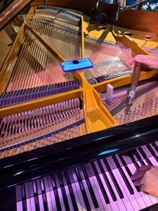 Gros plan sur la clé d’accord, les chevilles, les cordes et le clavier du piano