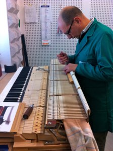 Travail de réglage sur une mécanique de piano déposée en atelier